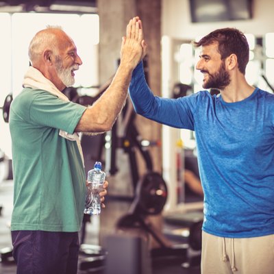 Männer geben sich ein Highfive im Fitnessstudio